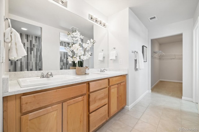 bathroom featuring double vanity, a sink, visible vents, and tile patterned floors