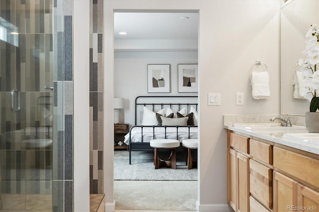 ensuite bathroom featuring connected bathroom, a shower stall, and double vanity