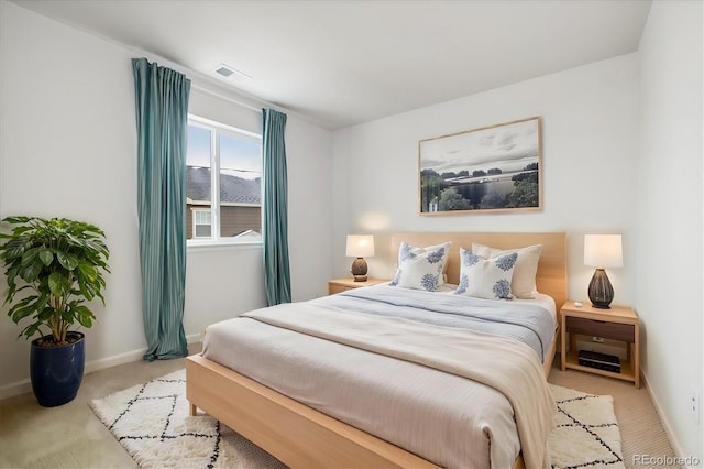 carpeted bedroom featuring baseboards and visible vents