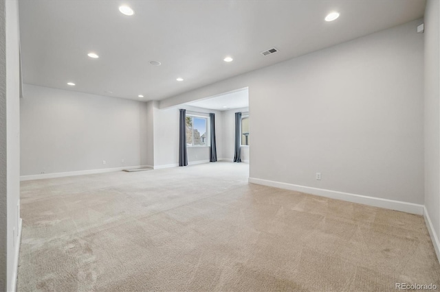 spare room featuring recessed lighting, visible vents, light carpet, and baseboards