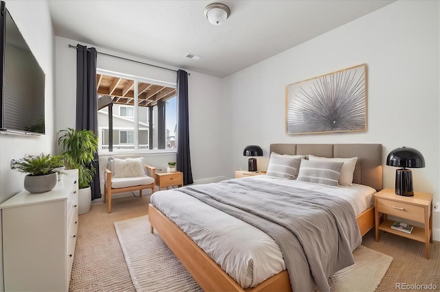 bedroom featuring visible vents and light colored carpet