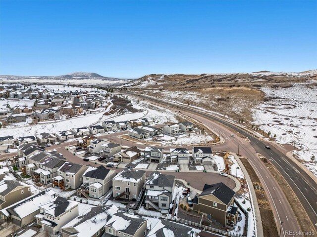 snowy aerial view with a residential view and a mountain view