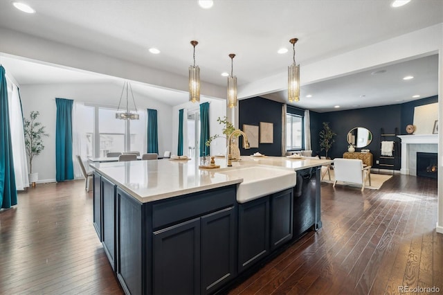 kitchen with dark wood-style floors, a tile fireplace, open floor plan, and a sink