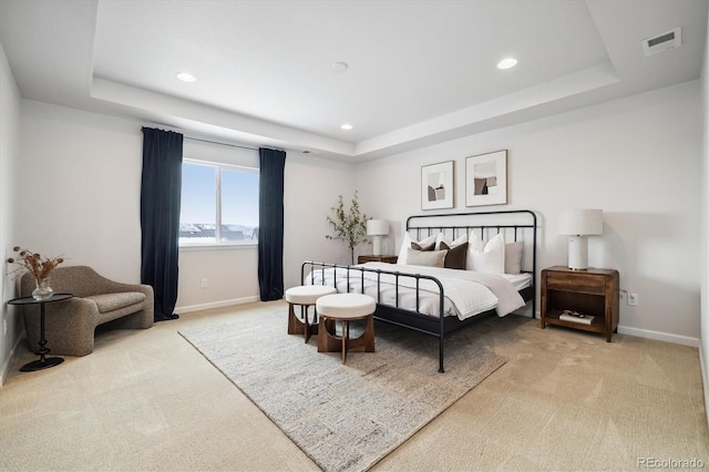 bedroom with carpet floors, a raised ceiling, and visible vents