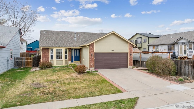 6760 Oakwood Blvd, Colorado Springs, CO 80923 - view of front facade with brick siding, driveway, and an attached garage
