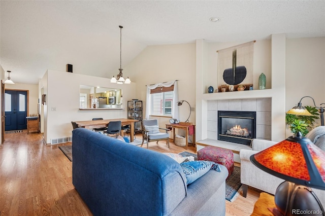 6760 Oakwood Blvd, Colorado Springs, CO 80923 - living area with a chandelier, a fireplace, wood finished floors, and high vaulted ceiling