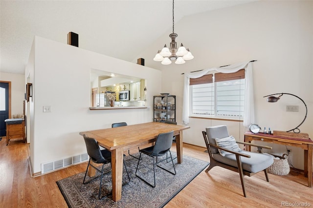 6760 Oakwood Blvd, Colorado Springs, CO 80923 - dining room featuring a chandelier, light wood-style flooring, and high vaulted ceiling