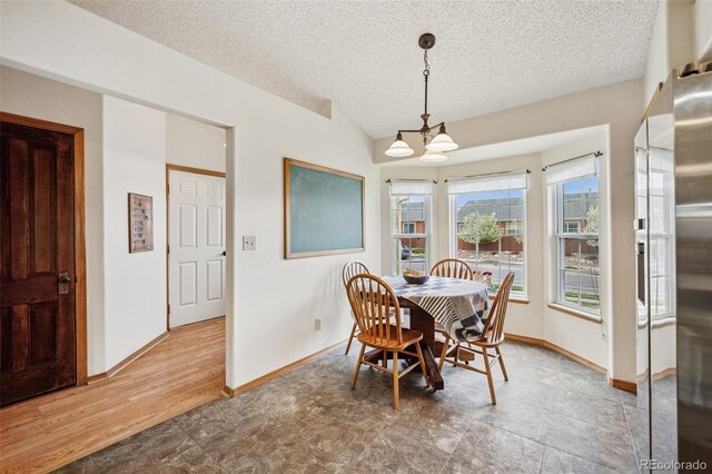 6760 Oakwood Blvd, Colorado Springs, CO 80923 - dining space with a chandelier, a textured ceiling, baseboards, and lofted ceiling