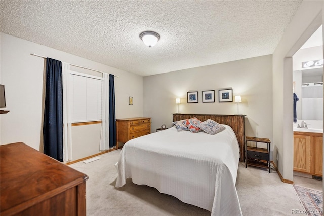 6760 Oakwood Blvd, Colorado Springs, CO 80923 - bedroom with light carpet, a textured ceiling, and ensuite bath