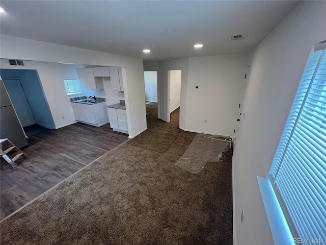 unfurnished living room featuring dark hardwood / wood-style floors and sink