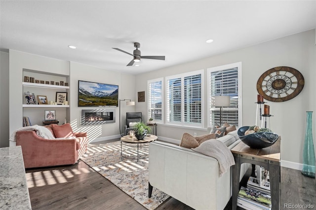 living room featuring dark wood-type flooring and ceiling fan