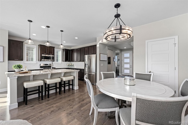 dining room with dark hardwood / wood-style flooring and a notable chandelier