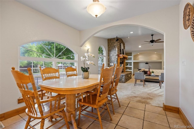 205 Beech St, Hudson, CO 80642 - dining space with arched walkways, built in features, light carpet, light tile patterned flooring, and ceiling fan