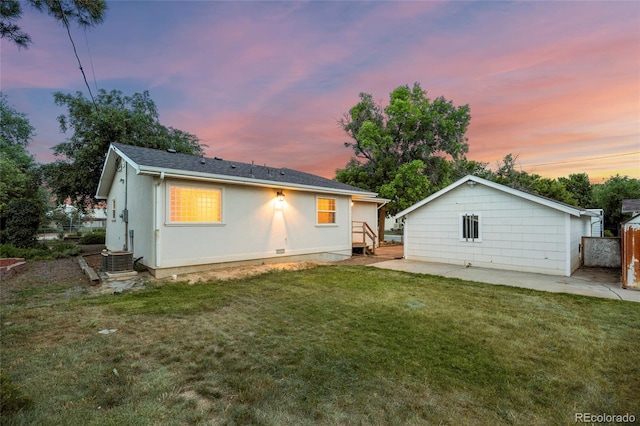 205 Beech St, Hudson, CO 80642 - back of property at dusk featuring a lawn and a patio