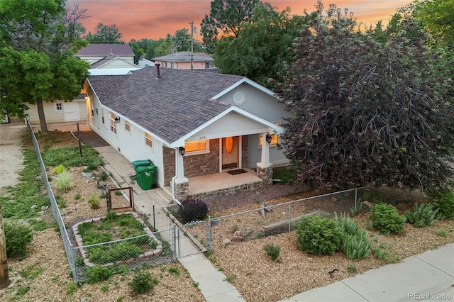 205 Beech St, Hudson, CO 80642 - view of front of property featuring a gate, a shingled roof, a porch, a fenced front yard, and stone siding