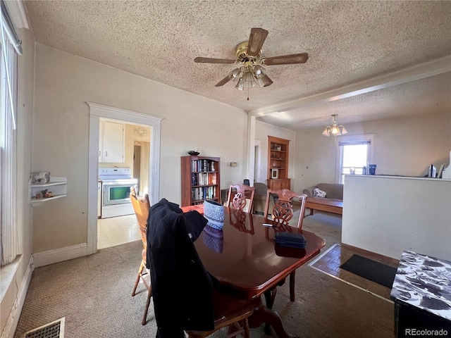 dining space with ceiling fan, carpet floors, and a textured ceiling