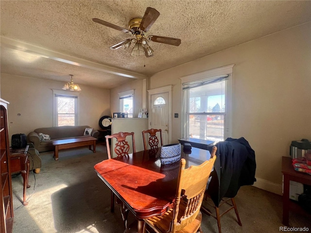 carpeted dining area with a textured ceiling and ceiling fan