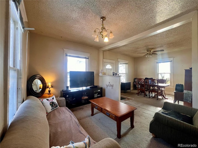 living room featuring ceiling fan with notable chandelier, carpet, and a textured ceiling