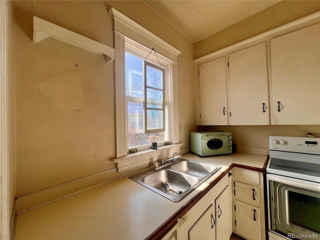 kitchen featuring white cabinetry, sink, and white electric range