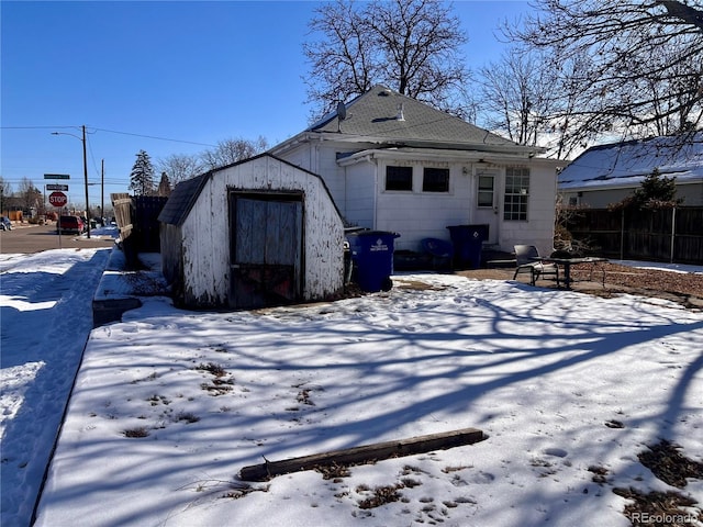 snow covered house with a storage unit