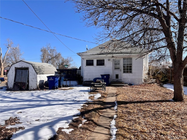 snow covered property with a shed