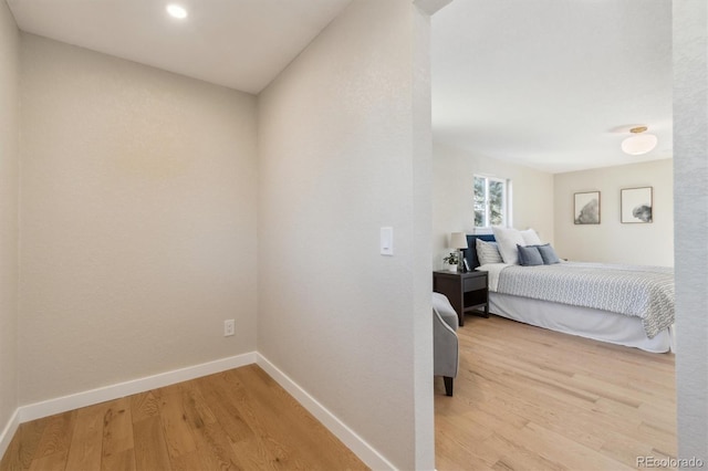 bedroom with light wood-type flooring and baseboards