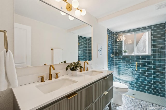 full bath featuring toilet, double vanity, visible vents, and a sink