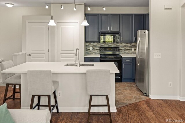 837 E 98th Ave Unit 405, Thornton, CO 80229 - kitchen with black appliances, backsplash, a breakfast bar, light countertops, and hanging light fixtures