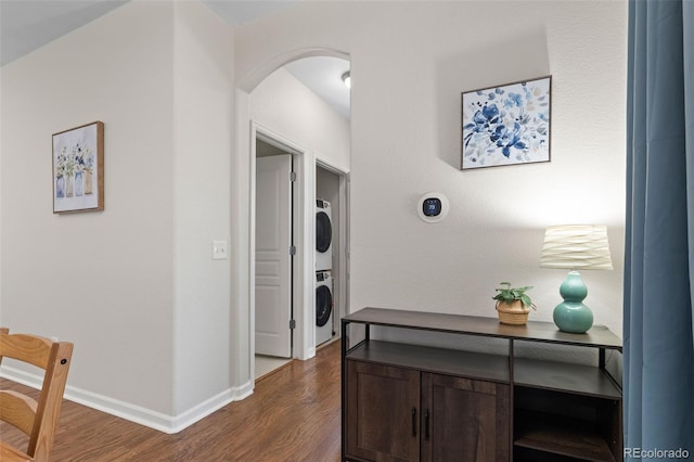 837 E 98th Ave Unit 405, Thornton, CO 80229 - hallway featuring stacked washing machine and dryer, dark wood-type flooring, and arched walkways