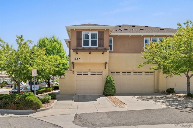 837 E 98th Ave Unit 405, Thornton, CO 80229 - view of front of property featuring stucco siding, a garage, and concrete driveway