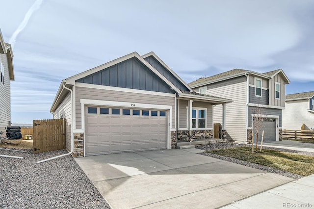 view of front of house with stone siding, board and batten siding, and concrete driveway