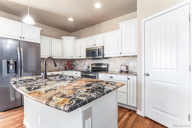 kitchen featuring white cabinets, appliances with stainless steel finishes, a center island with sink, and sink