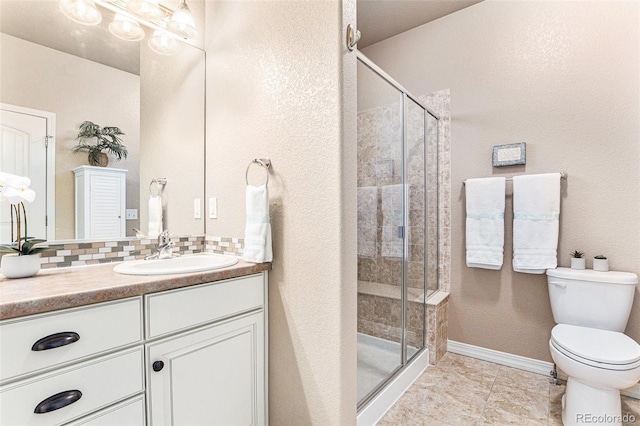 bathroom with decorative backsplash, toilet, vanity, and walk in shower