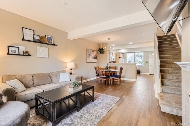 living room featuring an inviting chandelier, hardwood / wood-style floors, and beamed ceiling