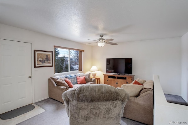 carpeted living room with ceiling fan and a textured ceiling