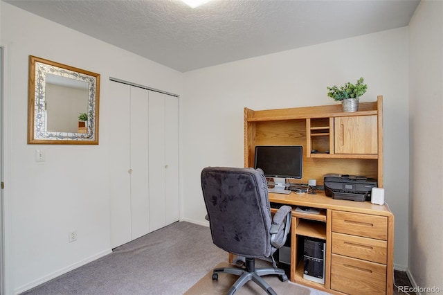 home office featuring carpet floors and a textured ceiling