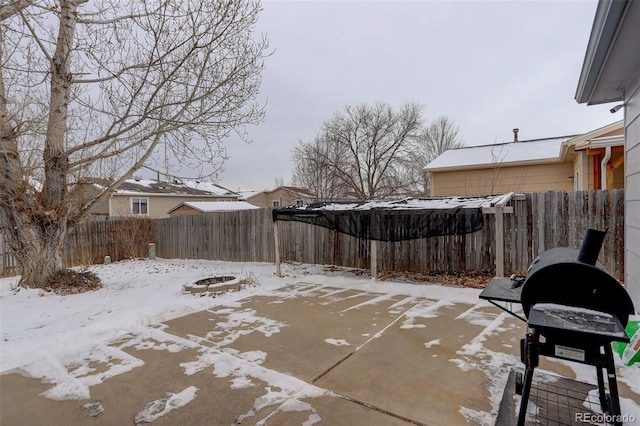 snow covered patio featuring an outdoor fire pit