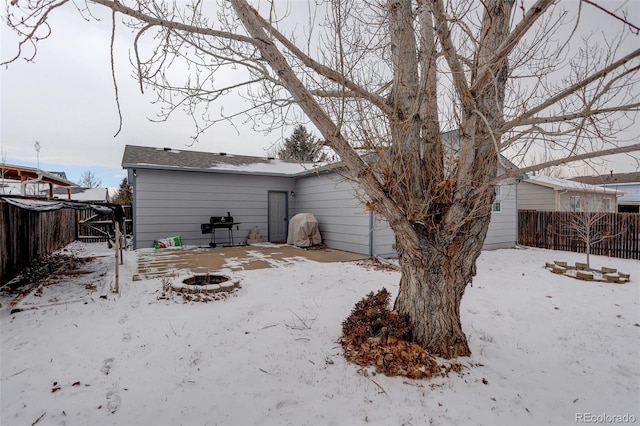 snow covered house with an outdoor fire pit