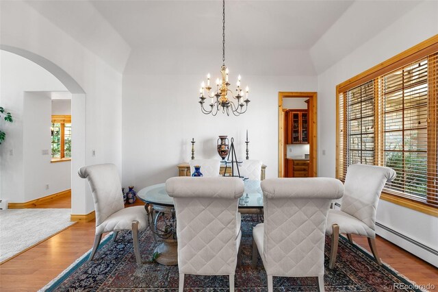 dining room featuring baseboard heating, a chandelier, and hardwood / wood-style floors