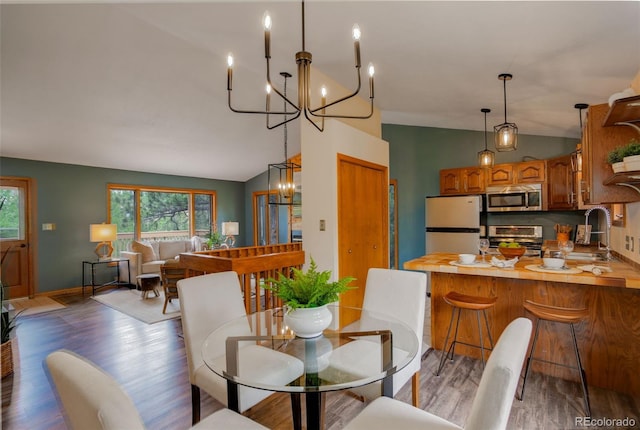 31150 Manitoba Dr, Evergreen, CO 80439 - dining space featuring a chandelier, lofted ceiling, and light wood-style floors