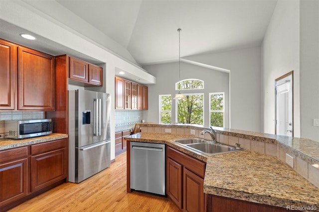 1513 Cannon Mountain Dr, Longmont, CO 80503 - kitchen featuring stainless steel appliances, a sink, lofted ceiling, tasteful backsplash, and decorative light fixtures