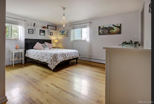 10373 W 75th Ave, Arvada, CO 80005 - bedroom featuring a baseboard radiator, light wood-type flooring, and a chandelier