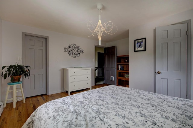 10373 W 75th Ave, Arvada, CO 80005 - bedroom with a chandelier, wood finished floors, and baseboard heating