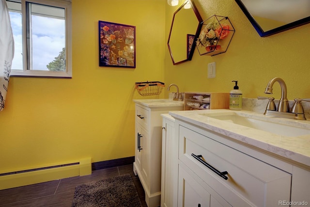 10373 W 75th Ave, Arvada, CO 80005 - bathroom featuring two vanities and baseboard heating