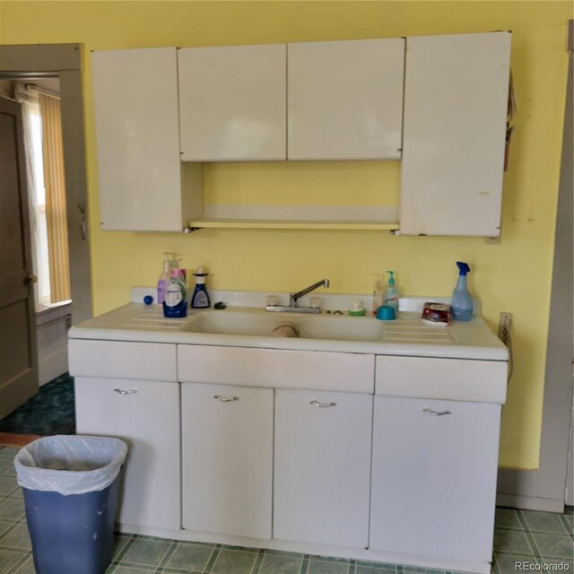 kitchen featuring tile flooring and white cabinetry