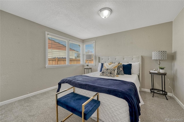 bedroom with a textured ceiling, carpet floors, a textured wall, and baseboards