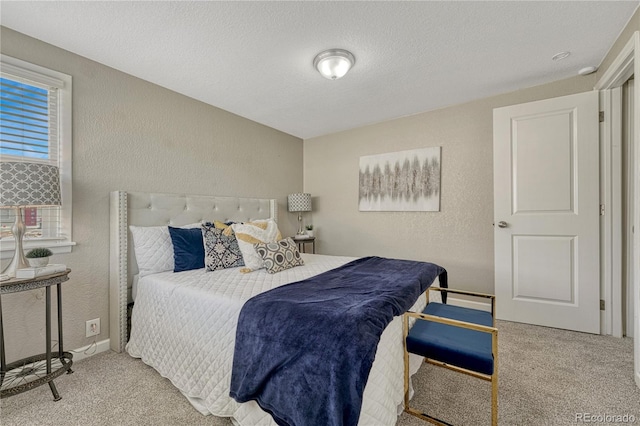 bedroom featuring a textured wall, carpet flooring, and a textured ceiling