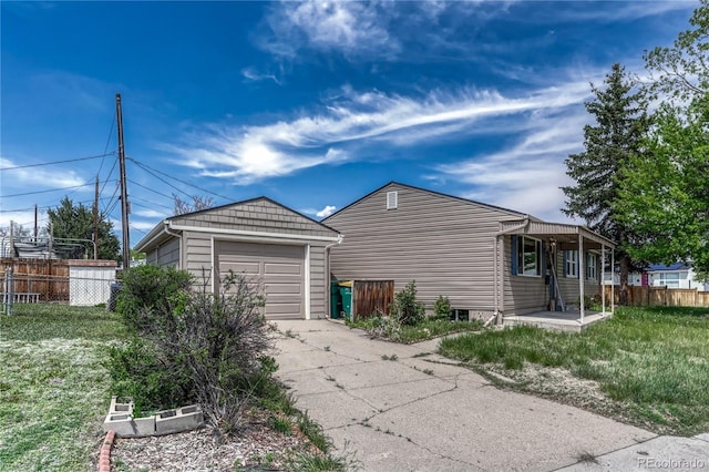 view of side of property featuring a detached garage and driveway