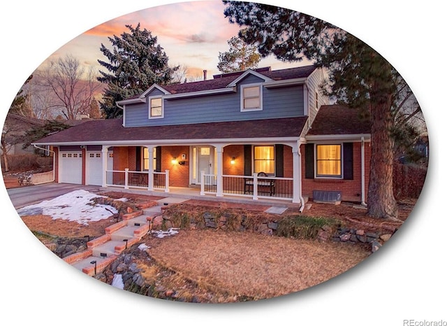 view of front of property featuring covered porch, brick siding, driveway, and an attached garage