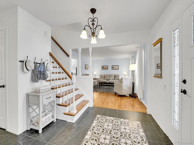 entryway featuring a notable chandelier, baseboards, and stairs